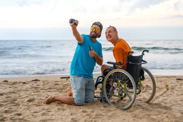 Two friends enjoying a day at the beach, one using a wheelchair